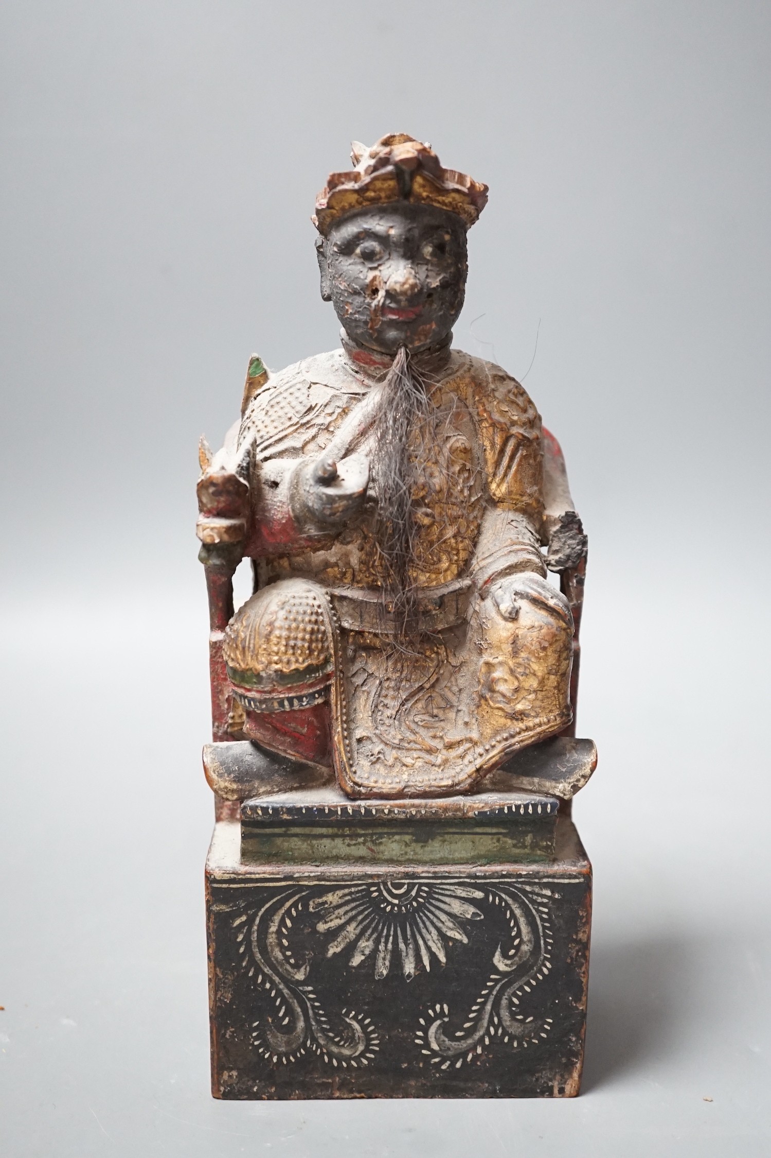 A 19th century Chinese painted wood figure with ink inscription verso, 24.5cms high